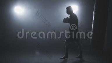 在斯洛-莫低光体育馆进行踢腿拳击训练。运动员在烟雾缭绕的体育馆进行拳击训练